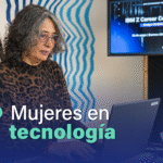 En la imagen se ve una mujer con una laptop en un ambiente de empresa de tecnología.