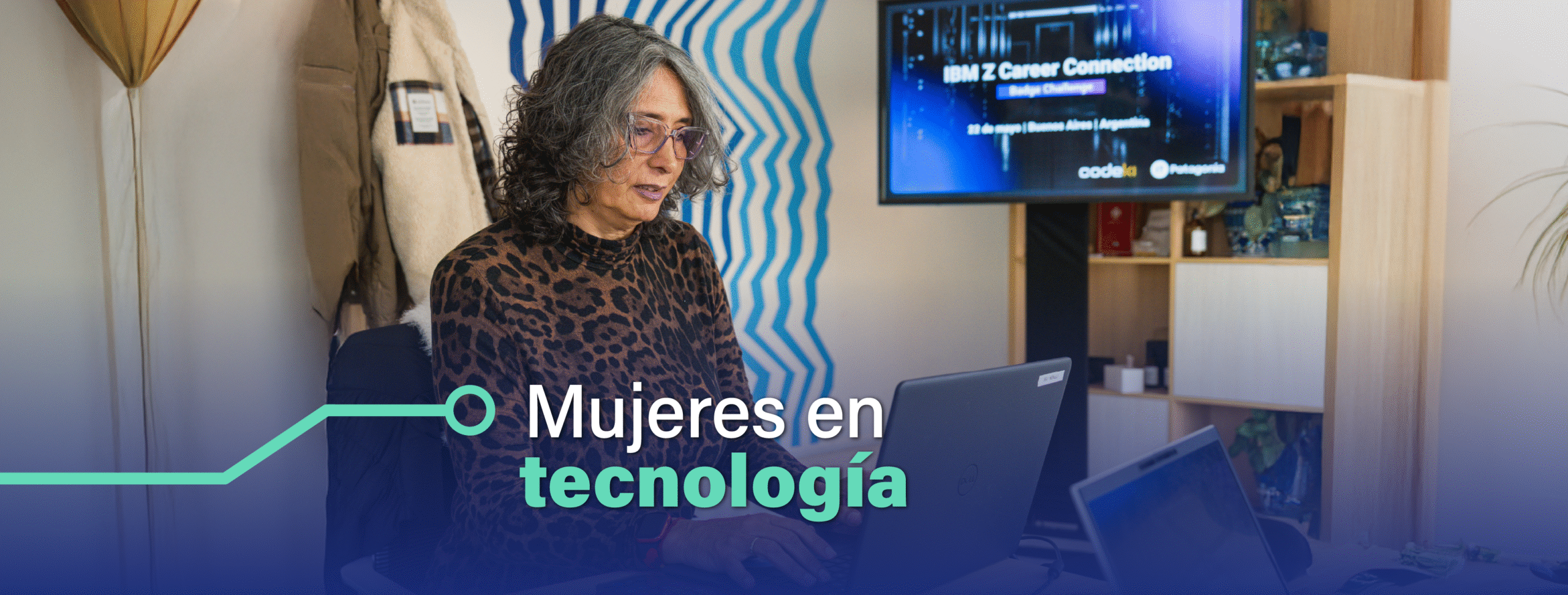 En la imagen se ve una mujer con una laptop en un ambiente de empresa de tecnología.