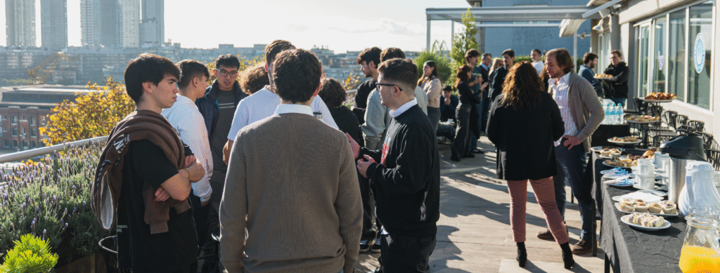 En la fotografía se ve a un grupo de personas de la generación z disfrutando de un momento de esparcimiento en el rooftop de IT Patagonia, en Puerto Madero.