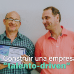 En la imagen se ve un grupo de dos mujeres y dos hombres sonriendo a cámara. Uno de los hombres sostiene en sus manos un certificado de finalización de un curso de formación en tecnología.